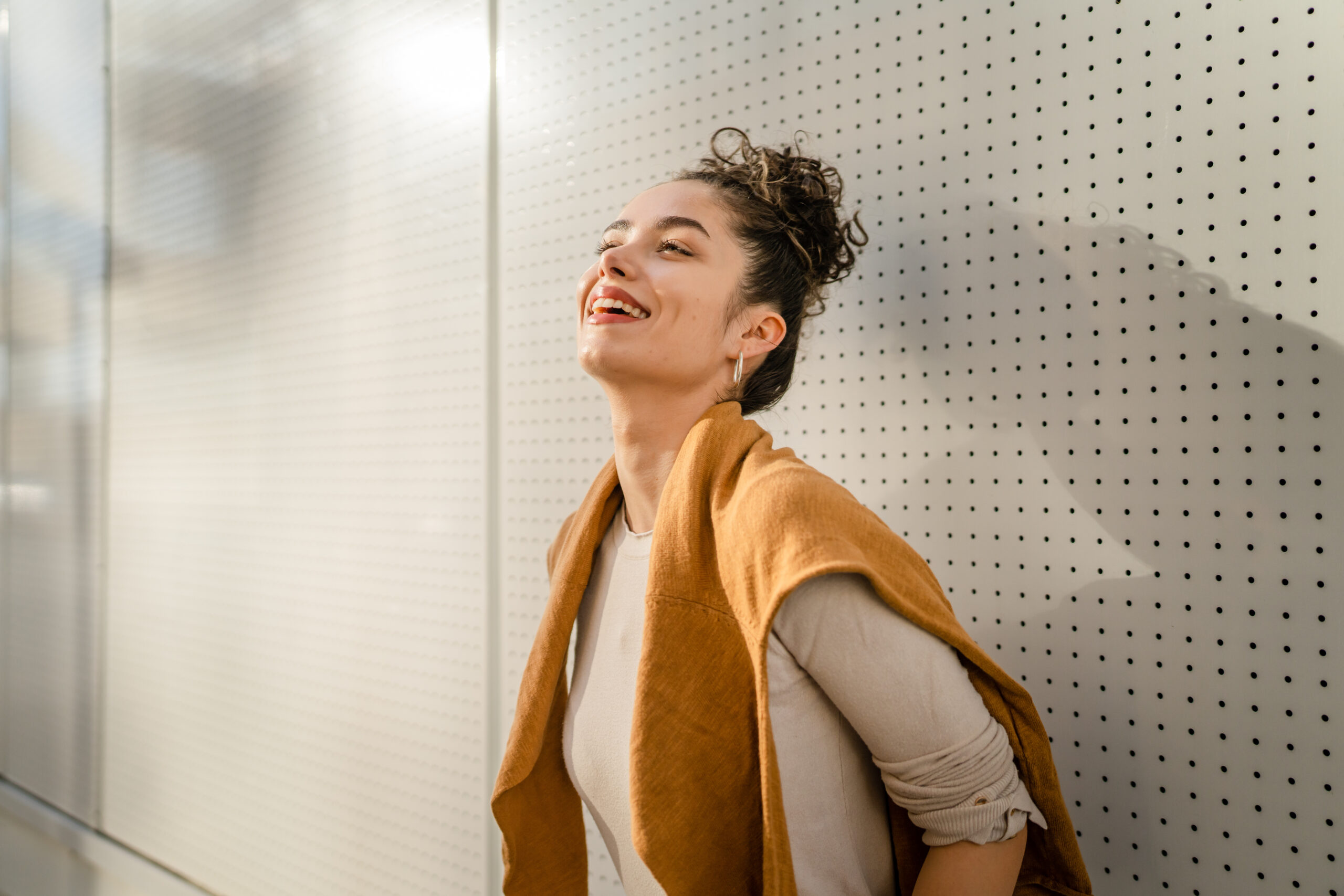 One woman young adult caucasian female stand outdoor posing portrait happy confident in front of white wall copy space